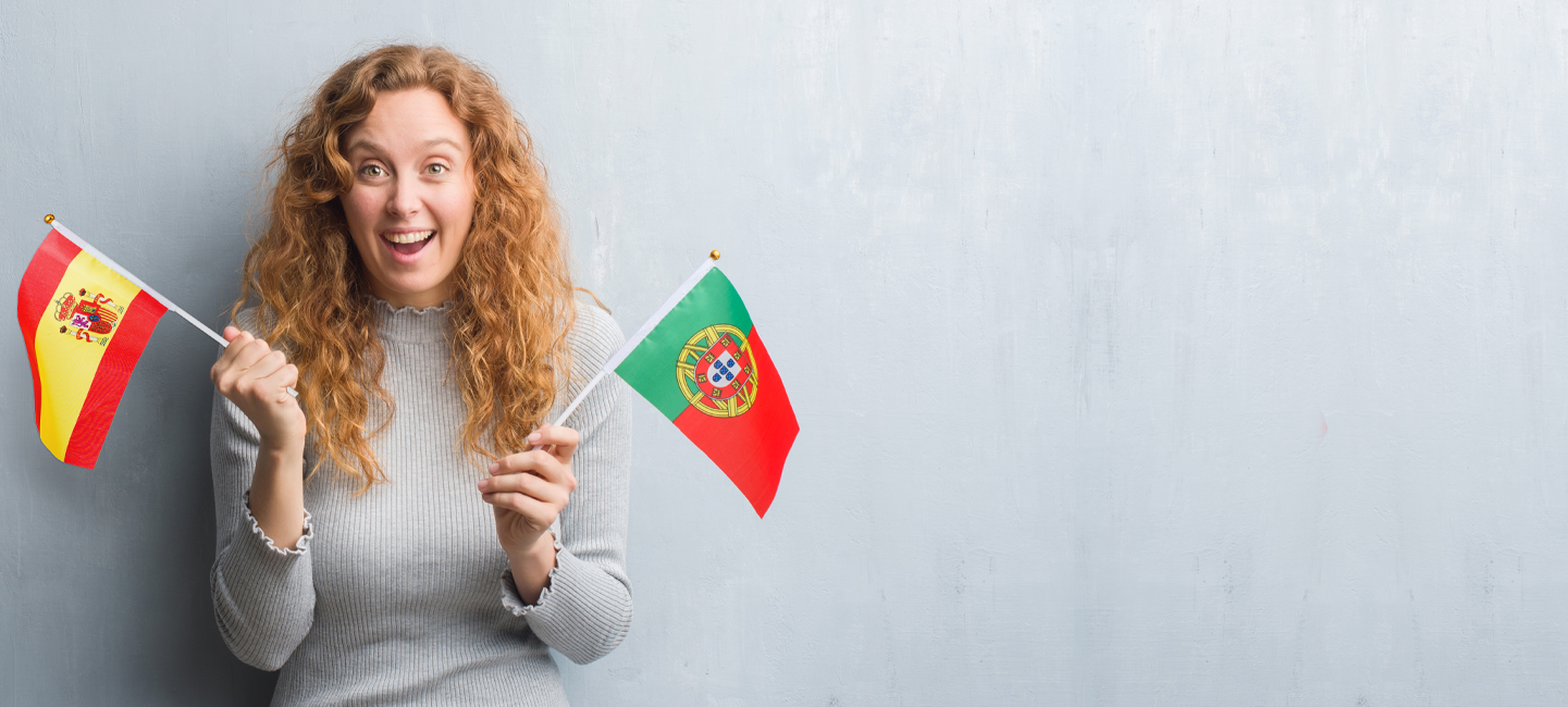 Rapariga com duas bandeiras, uma de Portugal e outra de Espanha.