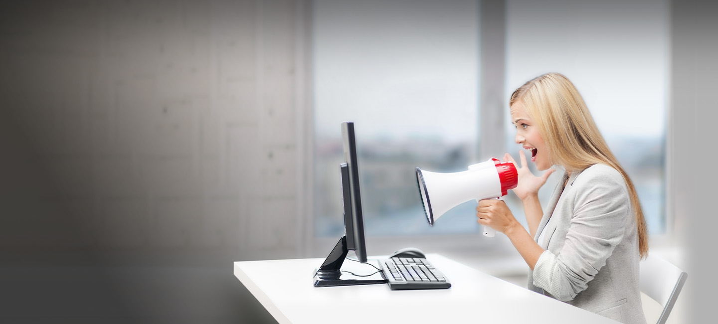 Senhora a falar para um computador através de um megafone.