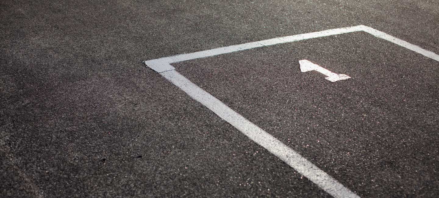 Estrada alcatroada, pintada com umas linhas brancas e o número 1