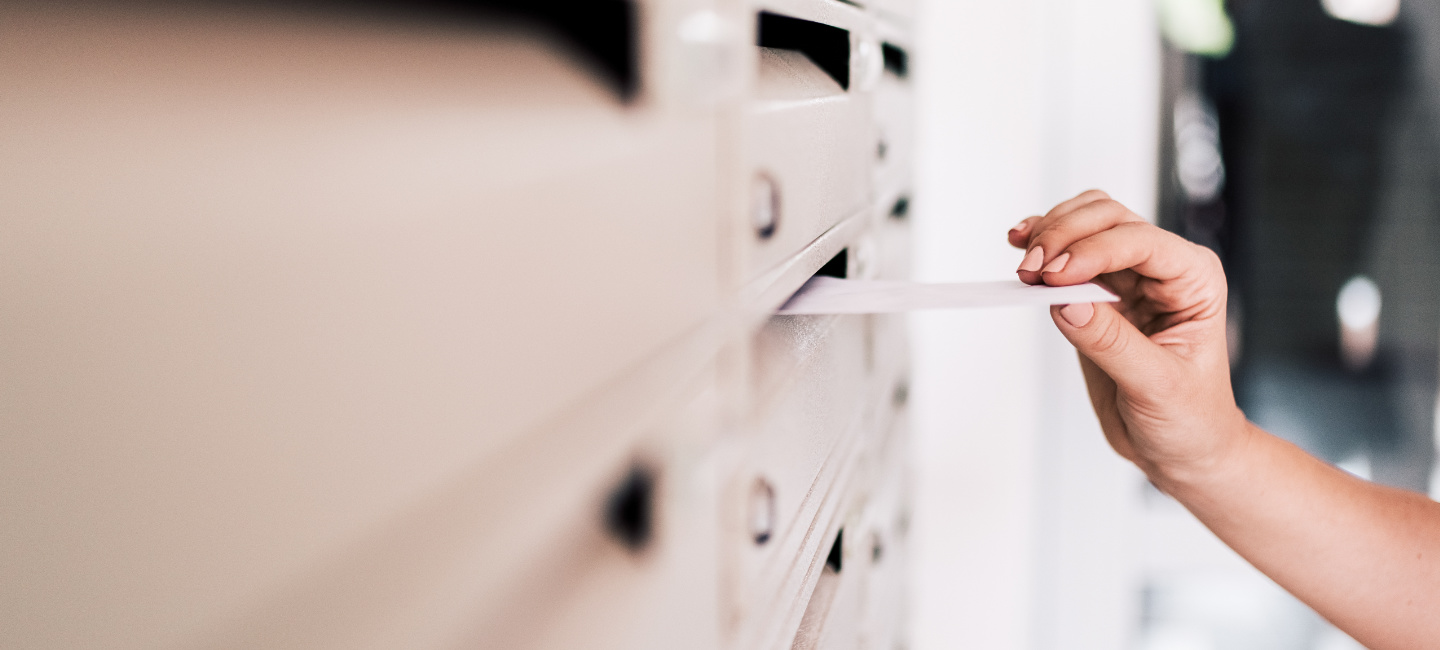 Carteiro a colocar carta na caixa do correio