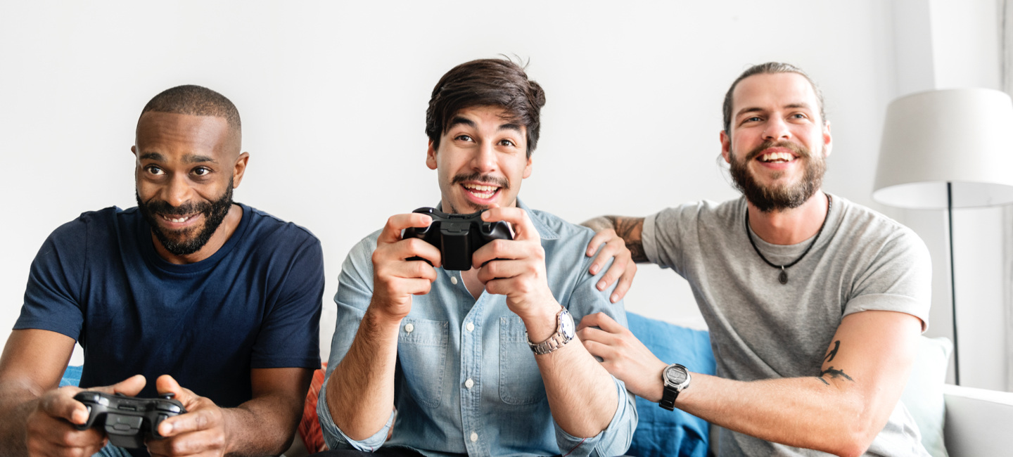 Três rapazes a jogar num sofá.